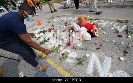 Ferguson, United States. 09th Aug, 2021. A visitor places flowers at the location of the shooting death of Michael Brown Jr. on the seven year anniversary in Ferguson, Missouri on Monday, August 9, 2021.Brown Jr. (18) was shot and killed by Ferguson Police officer Darren Wilson in 2014, after an altercation ensued when Brown attacked Wilson in his police vehicle for control of Wilson's gun until it was fired. Photo by Bill Greenblatt/UPI Credit: UPI/Alamy Live News Stock Photo