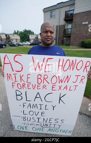 Ferguson, United States. 09th Aug, 2021. Michael Gardner holds a sign at the location of the shooting death of Michael Brown Jr. on the seven year anniversary in Ferguson, Missouri on Monday, August 9, 2021.Brown Jr. (18) was shot and killed by Ferguson Police officer Darren Wilson in 2014, after an altercation ensued when Brown attacked Wilson in his police vehicle for control of Wilson's gun until it was fired. Photo by Bill Greenblatt/UPI Credit: UPI/Alamy Live News Stock Photo