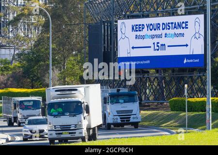 A roadside billboard with COVID-19 social distancing health advisory warning on Joyce Drive near Sydney Airport in Mascot, New South Wales, Australia. Stock Photo