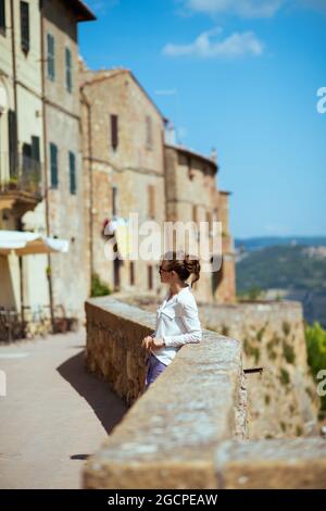 Travel in Italy. Seen from behind young solo traveller woman in Pienza in Tuscany, Italy. Stock Photo