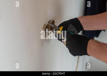 one electrician installs the light in the apartment where the repair Stock Photo