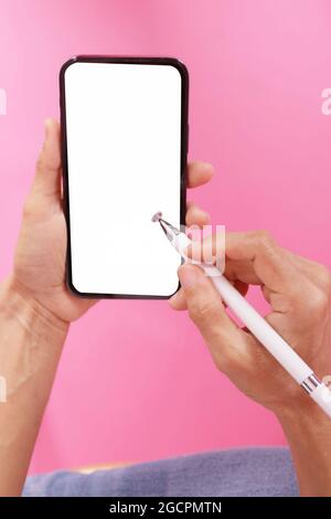 hand holding phone with a pen for a smartphone.on the pink scene isolate.empty space for text Stock Photo