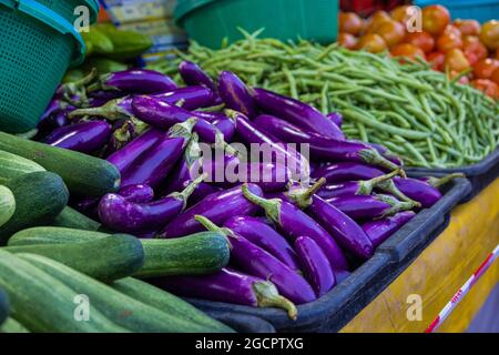 Vegetables on a counter of a vegetable shop in the fresh market. Aubergine or eggplant, beans and cucumber on the counter of the stand. The Putrajaya, Stock Photo