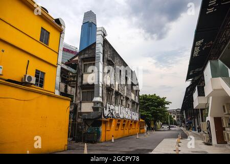 Kuala Lumpur, Malaysia - October 04, 2020: Old house with graffiti at the back roads of Kuala Lumpur. In the background the new landmark of Malaysia, Stock Photo