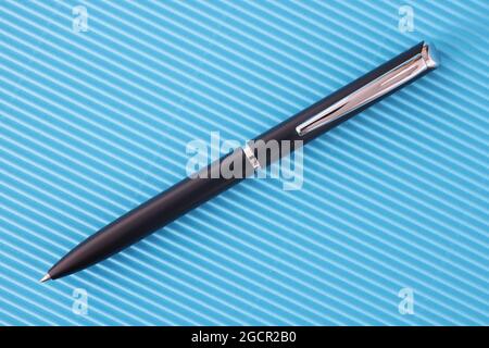 Black classic ballpoint pen on blue background Stock Photo