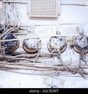 Old telephone junction boxes on a white wall Stock Photo