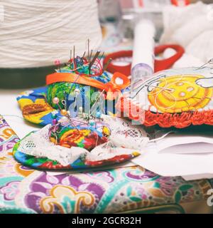 Sewing needles on a pillow, needlework threads and accessories. Selective Focus Stock Photo