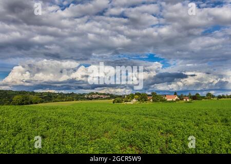 Cumulus storm clouds over rural farmland and village in central France. Stock Photo