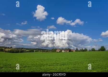 Cumulus storm clouds over rural farmland and village in central France. Stock Photo