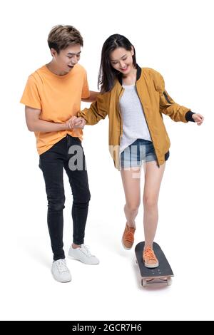 Happy young couple enjoying skateboarding Stock Photo