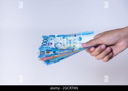 Fan of  Philippines peso  banknotes in female hand. Woman's hands show Philippine pesos money. Girls hands holding money of Philippines. Asian currenc Stock Photo