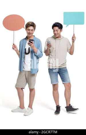 Happy young friends using smartphone Stock Photo
