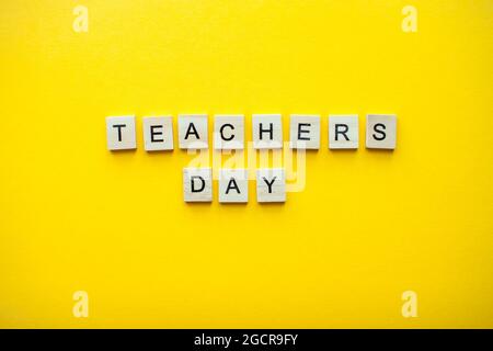The inscription teachers day from wooden blocks on a bright yellow background Stock Photo
