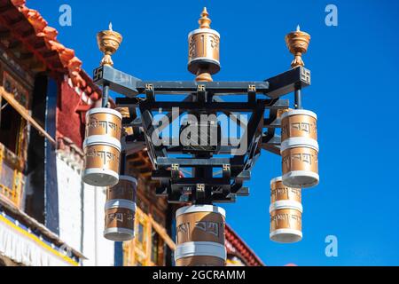 Lhasa, Tibet, China - November 15, 2019:  Buddhist prayer drums on the  bakuo road around the Jokhang Temple. People walking this street clockwise for Stock Photo