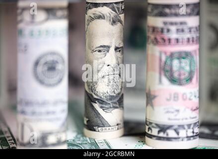 Close up to rolled up 50 US dollar . Macro photography of rolled US banknotes. In the background further nomination of US money. The Portrait on the 5 Stock Photo