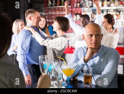 Troubled man at office party Stock Photo