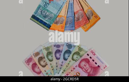 Detailed close up to the Chinese and Malaysian currency on white grey background. Fan of Malaysia Ringgit and China  Renminbi money. Specimen notes of Stock Photo