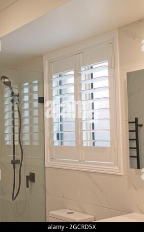 Luxury white plantation shutters in bathroom Stock Photo