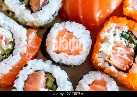 Eating various sushi. Maki, uramaki, hosomaki, sahimi and nigiri rolls set in a plate, close up composition Stock Photo