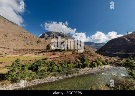 The Mountain landscape of Bhutan, the Paro Chu River beside the Paro - Thimphu Highway. White Clouds on blue sky. Scenic view to the bhutanese Himalay Stock Photo