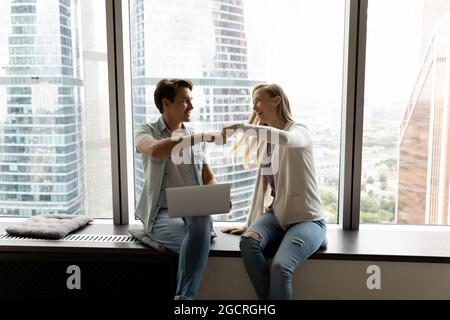 Happy business teammates, office friends, buddies giving fist bump Stock Photo