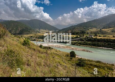 The longest suspension bridge in Himalaya near the town of Punakha in the Himalaya of Bhutan. Known for the Punakha Dzong, a 17th-century fortress at Stock Photo