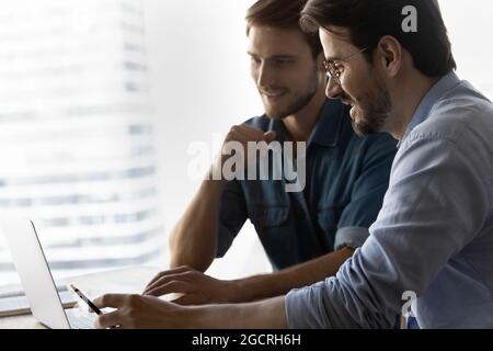 Happy business team members using laptop, working together Stock Photo