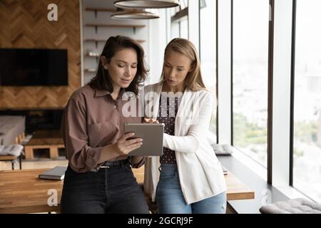 Female office employee showing work content on tablet Stock Photo