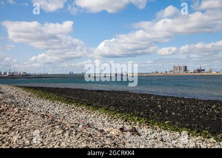 Hartlepool Nuclear Power Station and decommisioned oil rigs at Seaton Port as viewed from South Gare,Redcar,England,UK.Dredger approaches Teesport Stock Photo