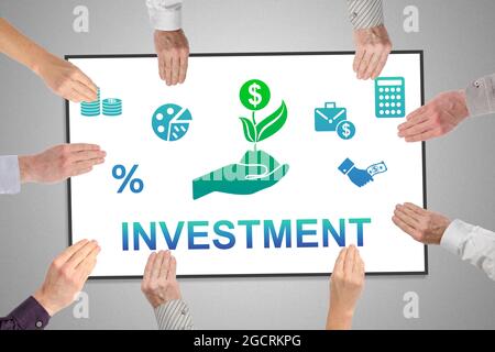 Investment concept on a whiteboard held by hands Stock Photo