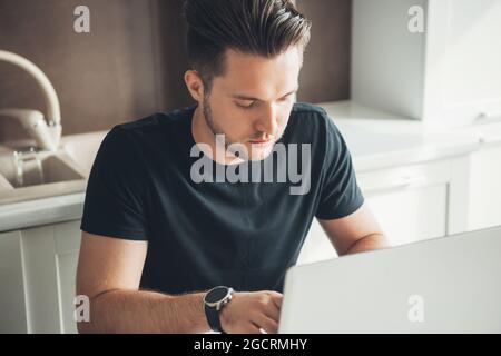 Portrait of entrepreneur that works on laptop from home. Digital communication. Corporate development. Sitting man. Stock Photo