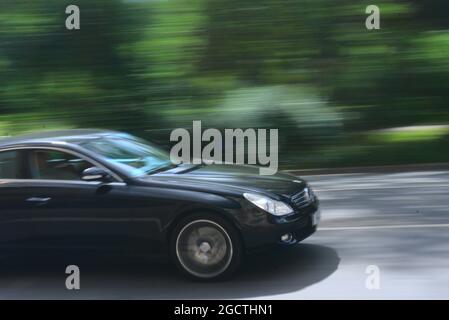 Black Mercedes limousine pacing through the city with a blurred park in the background in Frankfurt, Germany Stock Photo