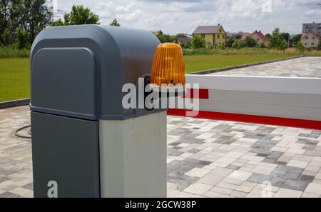 Close the gate. Automatic security system. Automatic entry system. Yellow light signal with a street barrier. Barrier gates Automatic security system Stock Photo