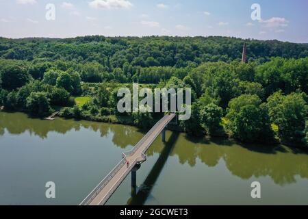 Witten, North Rhine-Westphalia, Germany - Ruhr landscape, Nachtigall bridge over the Ruhr in the Muttental valley, in the back chimney of the LWL indu Stock Photo