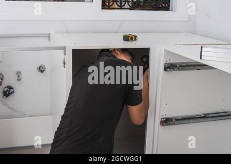 Man assembling a kitchen cabinet Stock Photo