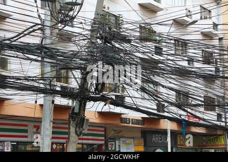 MANILA, PHILIPPINES - NOVEMBER 24, 2017: Tangled cables and chaotic wires in Manila, Philippines. Metro Manila is one of the biggest urban areas in th Stock Photo