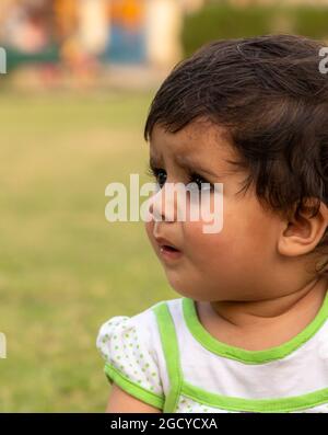 cute indian baby girl playing in the park.