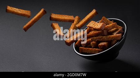 Falling rye croutons on black background  Stock Photo