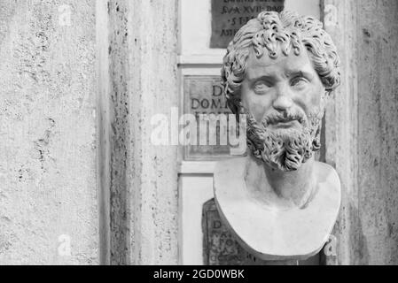 Black and white photo of ancient roman bust portraiting a mature bearded man looking aside Stock Photo