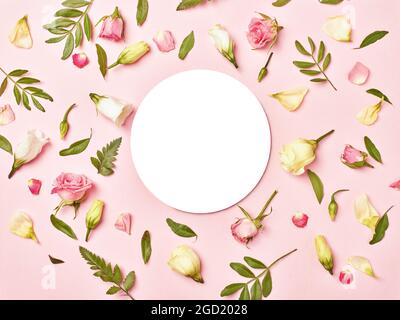 Close up of a note paper invitation card flat lay in floral environment, nature concept Creative layout made of flowers and leaves. Floral Greeting ca