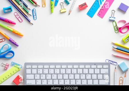 School supples and keyboard on white background. Flat lay, top view colorful stationery. E-learning, online school concept. Stock Photo
