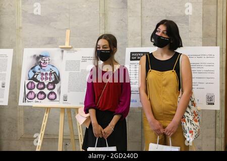 KYIV, UKRAINE - AUGUST 10, 2021 - Visitors in face masks are pictured during the opening of the SHE is SCIENCE exhibition that features 12 artworks cr Stock Photo