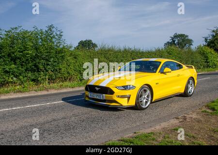 2018 yellow Ford Mustang 2dr 5038 cc petrol fast coupe en-route to Capesthorne Hall classic July car show, Cheshire, UK Stock Photo