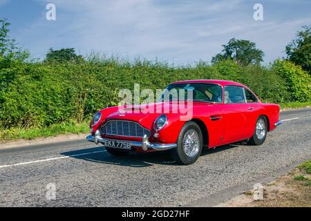 1964 60s red Aston Martin DB5 3995cc, 2dr coupe en-route to Capesthorne Hall classic July car show, Cheshire, UK Stock Photo