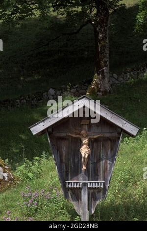 Carved wooden Jesus Christ on cross in rural setting, Berchtesgaden, Bavaria, Germany Stock Photo