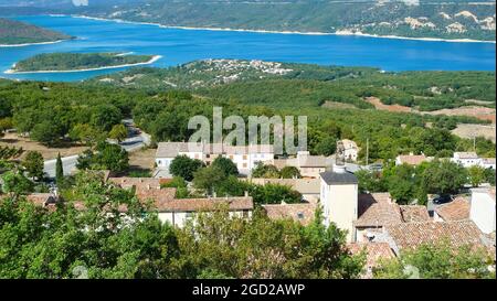 View over village into valley with blue beautiful lake in summer - Lac de sainte croix, France (focus on village) Stock Photo