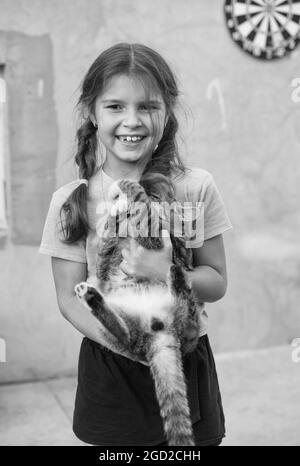 Treats for your furry friend. Happy child hold cat. Pet breed animal. Pet clinic. Veterinary hospital. Black and white. Practicing veterinarian. For w Stock Photo