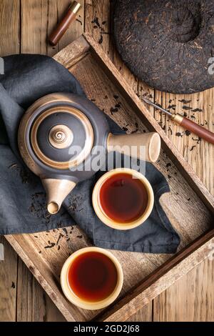 Medicinal Pu-erh tea in ceramic cups on wooden background Stock Photo