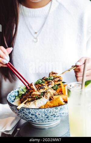 Vietnamese vermicelli noodle bowl with pork skewers and spring rolls Stock Photo