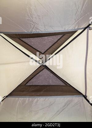 Water drops on blue fiber waterproof fabric after rain. View from bottom up in light green tent with morning raindrops, Stock Photo